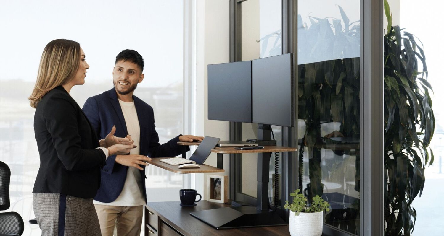 two individuals collaborating in front of an electric converter in an office setting